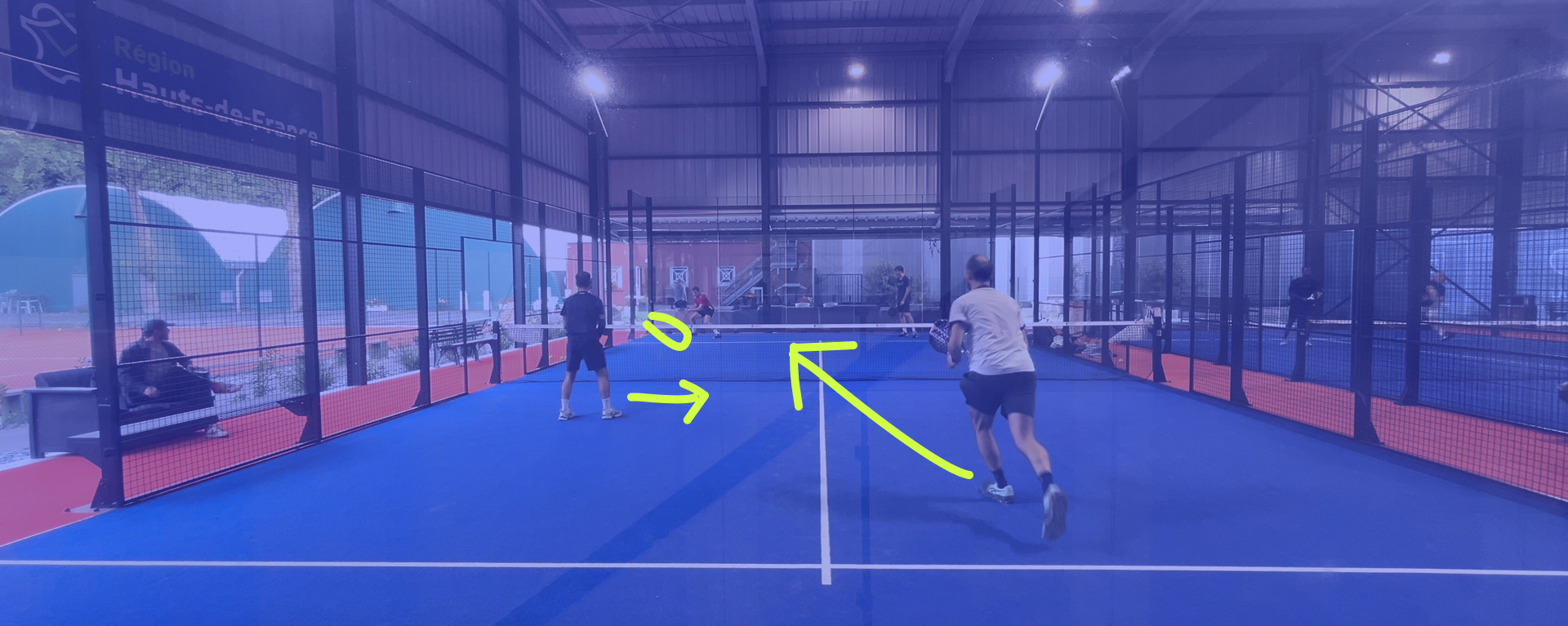 Coach de padel analysant un match avec des annotations tactiques dans une académie